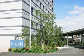 A modern building with a sign reading "Fairfield by Marriott" and a landscaped garden area. - Fairfield by Marriott Kagoshima Sakurajima (Tarumizu)