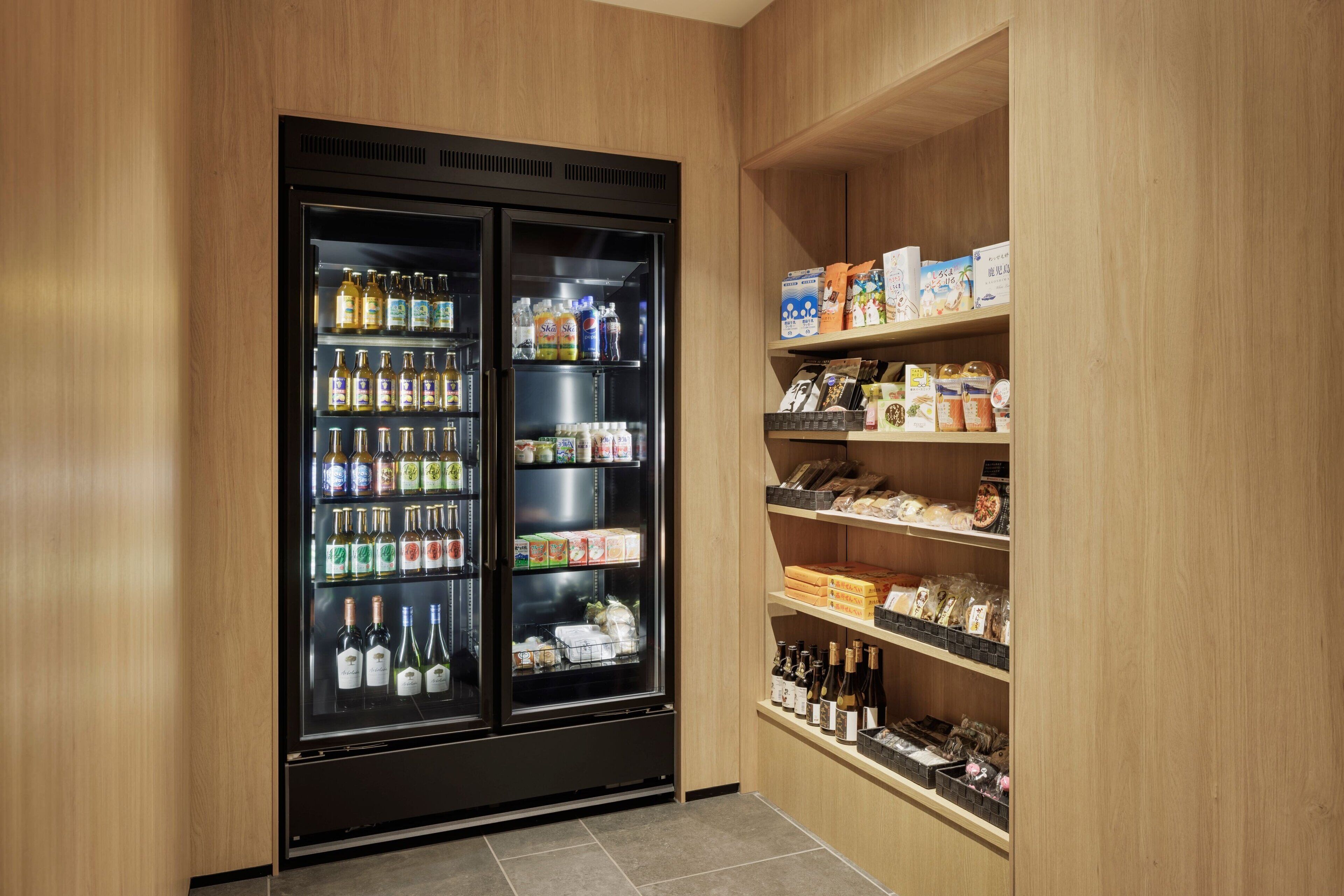 A minibar with a variety of beverages and snacks, including alcohol and packaged goods.