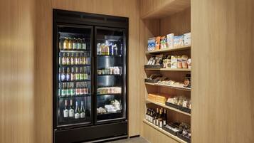 A minibar with a variety of beverages and snacks, including alcohol and packaged goods.