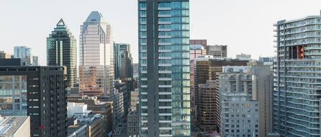 Un edificio de gran altura con fachada de vidrio moderna, rodeado de otros edificios altos en un entorno urbano.
