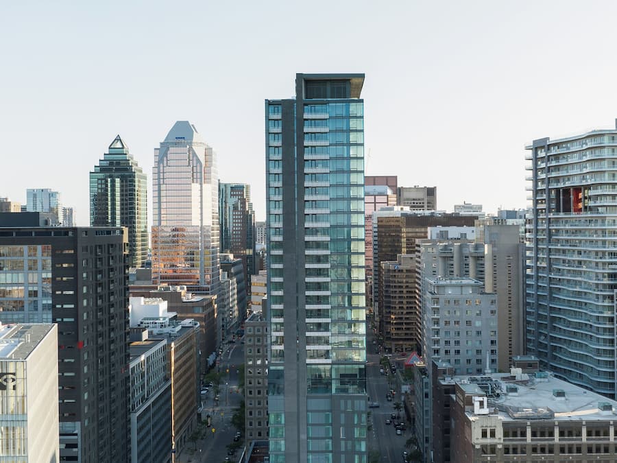 A high-rise building with a modern glass facade, surrounded by other tall buildings in an urban setting.