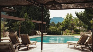 A poolside area with lounge chairs and a view of mountains. - Rondaia Boutique Vineyard Stay – Mallorca, Tramuntana (Esporles)