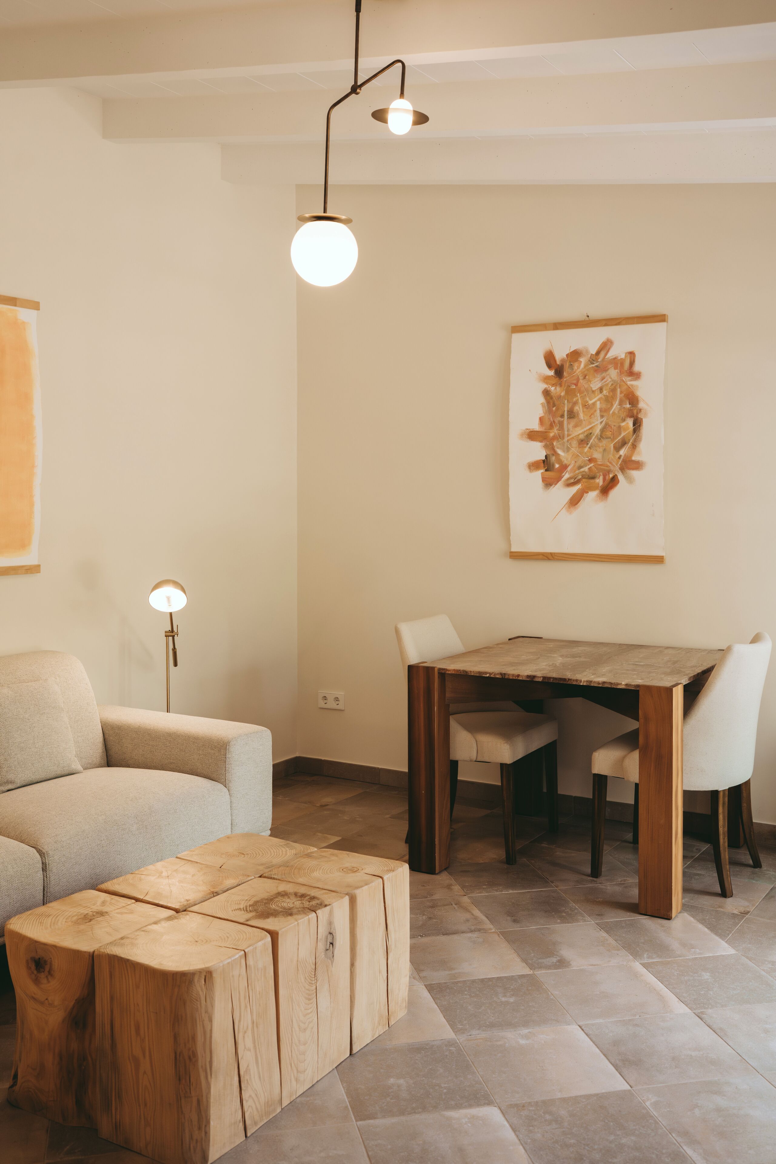 Een moderne woonkamer met een houten salontafel, een bank, een eettafel met stoelen en een vloerlamp.