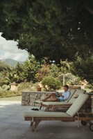 Una piscina al aire libre, sombrillas, sillones reclinables de piscina