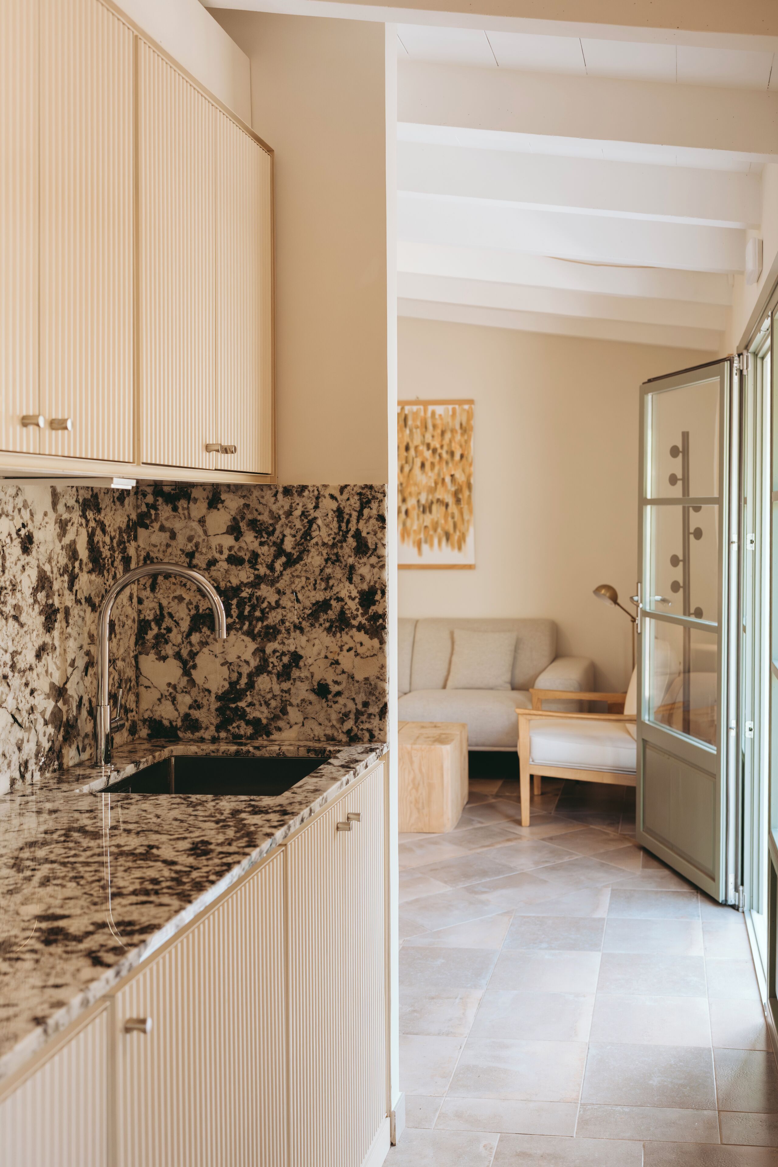 A modern kitchen with a granite countertop, a built-in sink, and wooden cabinets.