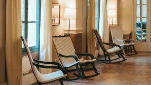 A room with wooden flooring, a ceiling with exposed beams, and three rocking chairs near a window with curtains. - Rondaia Boutique Vineyard Stay – Mallorca, Tramuntana (Esporles)