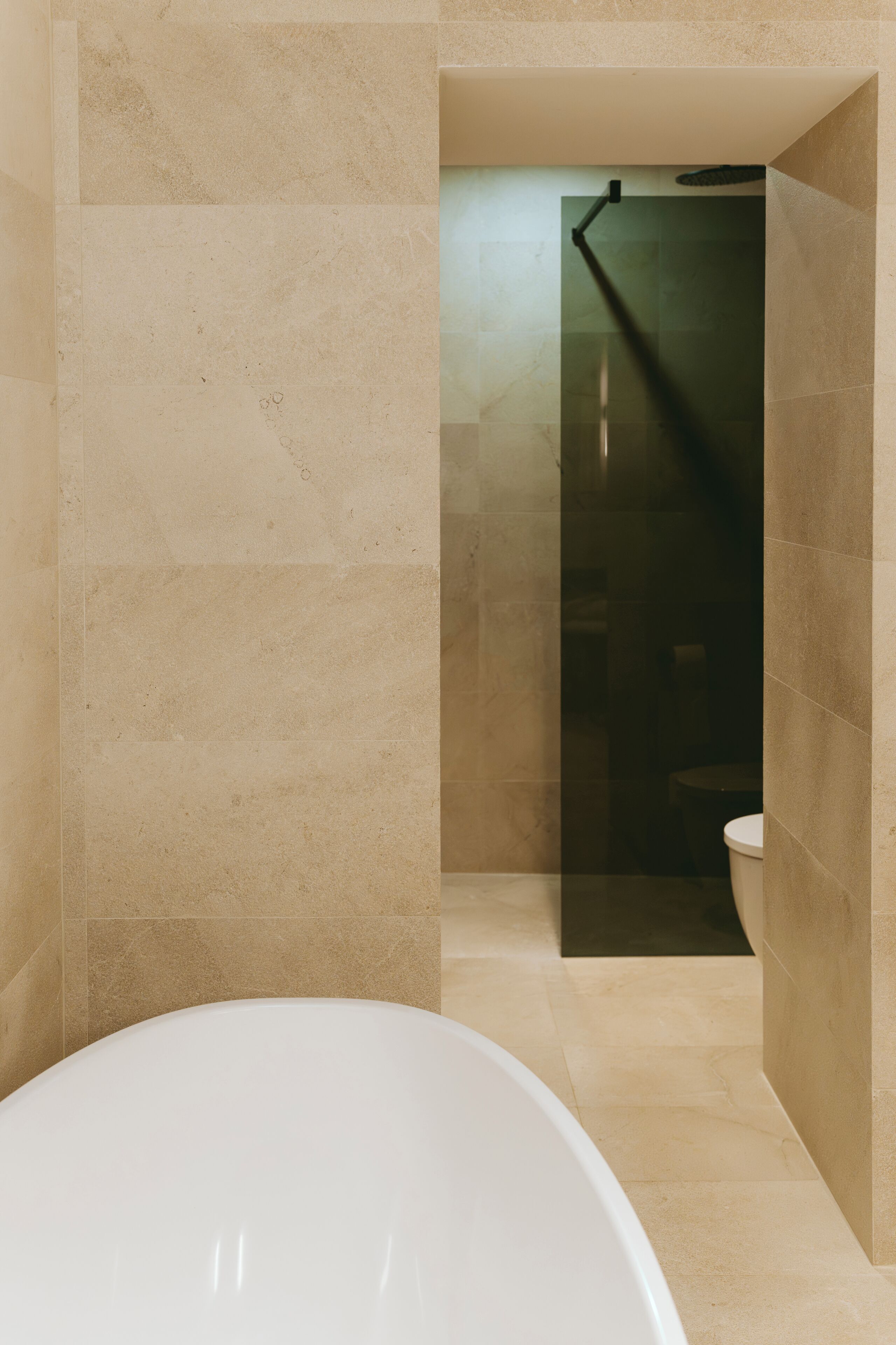 Un baño moderno con una bañera independiente, una ducha con mampara de vidrio y un inodoro.