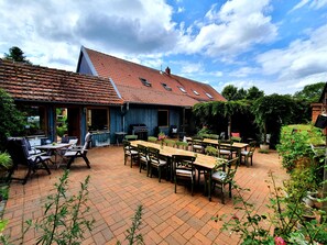 Eine Terrasse mit Sitzgelegenheit und Grill.
