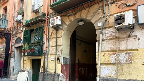 Un bâtiment doté d’une façade en pierre, d’une entrée bien visible et de plusieurs unités de climatisation.