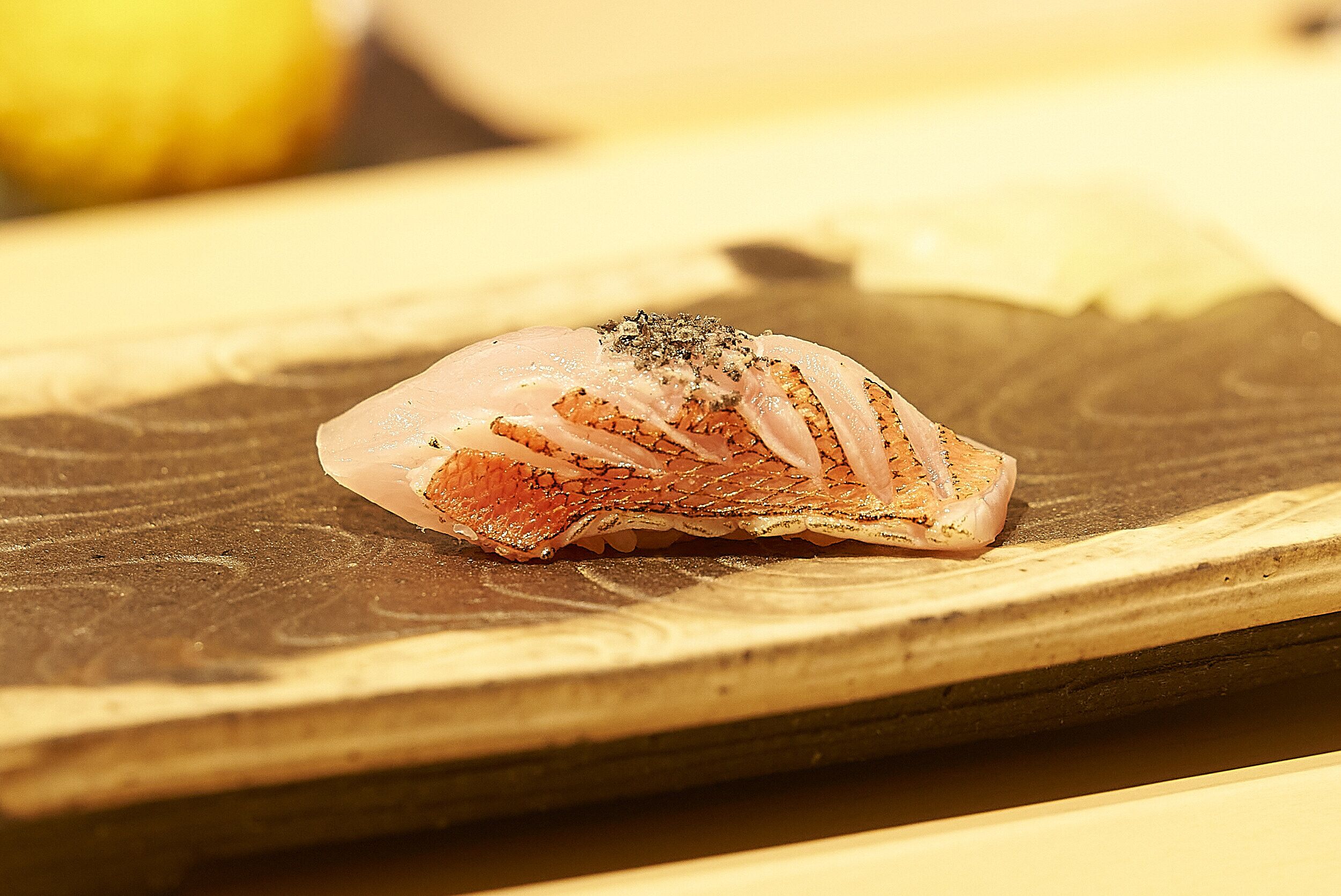 A piece of raw salmon on a wooden cutting board.