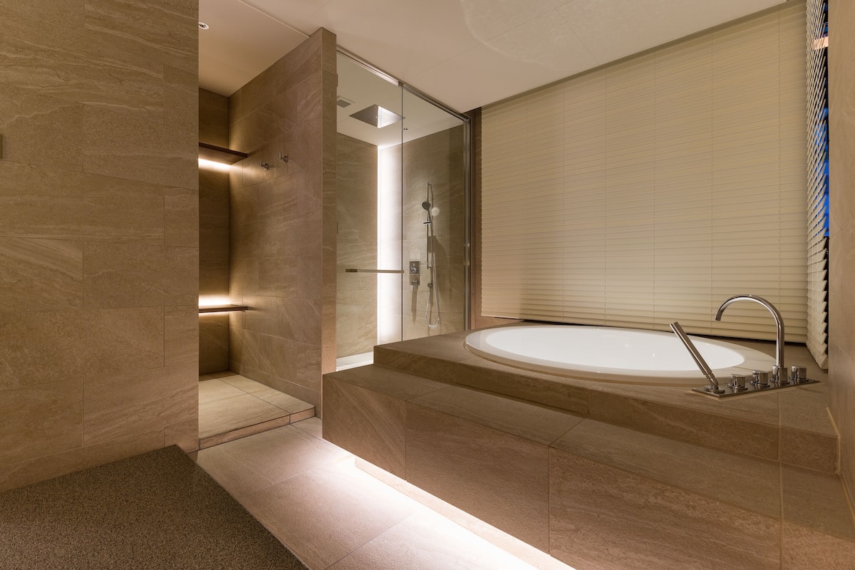 A modern bathroom with a large bathtub, a glass shower enclosure, and a walk-in shower.