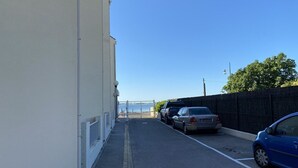 A narrow street with parked cars and a building on one side. - Modern Studio with Terrace, AC, and Parking (Balaruc-les-Bains)