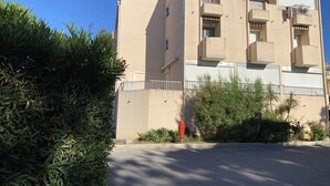 A multi-story building with balconies, a flat roof, and a beige exterior. - Modern Studio with Terrace, AC, and Parking (Balaruc-les-Bains)