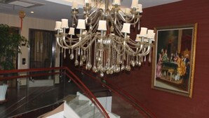 A grand chandelier, a staircase with red railings, and a classical painting on the wall. - Youfeel Hotel (Shanghai)