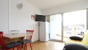 A compact living space with a dining area, a kitchenette, and a sofa. - Renovated T2 with Terrace Near Thau Lagoon, 800m from Thermes, Parking, Wifi, A/C (Balaruc-les-Bains)