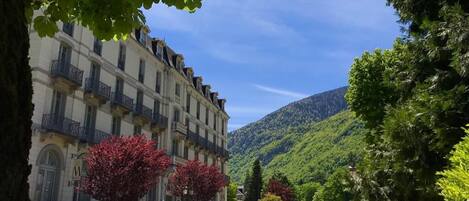A hotel with a classic European architectural style, featuring a symmetrical facade with multiple balconies and a central entrance.
