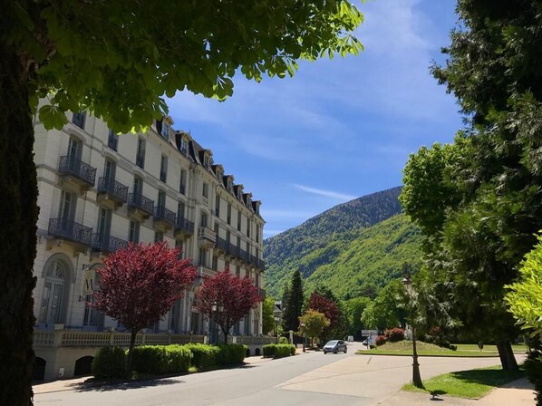 A hotel with a classic European architectural style, featuring a symmetrical facade with multiple balconies and a central entrance.