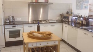 Una cocina moderna con una mesa de madera, un botellero y una campana extractora de acero inoxidable.
