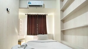 A hotel room with a bed, a remote control, and a rolled towel on the bed. - Spacious 2Br At 7Th Floor Cinere Resort Apartment (Depok)