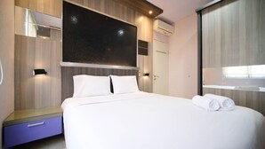 Una habitación de hotel moderna con una cama grande, un armario, una tocador con espejo y un equipo de aire acondicionado.