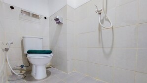 A small bathroom with a toilet, a shower, and a hand dryer.