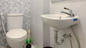 Un baño con inodoro, lavamanos y ducha.