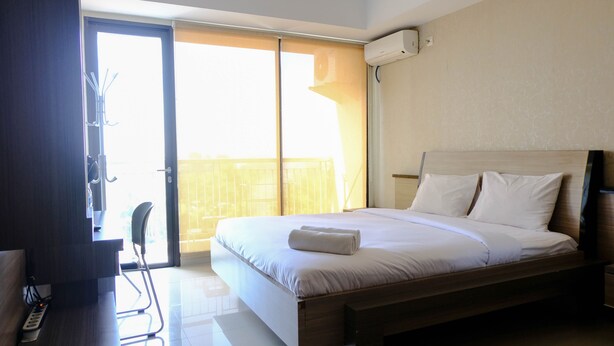 Ein Hotelzimmer mit Bett, Schreibtisch mit Stuhl, Fenster und Klimaanlage.