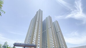 Een hoog appartementencomplex met meerdere balkons en een bord waarop staat dat het een Riverview Apartment is.