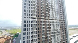 Um edifício alto com várias varandas e vista para o horizonte urbano ao fundo.
