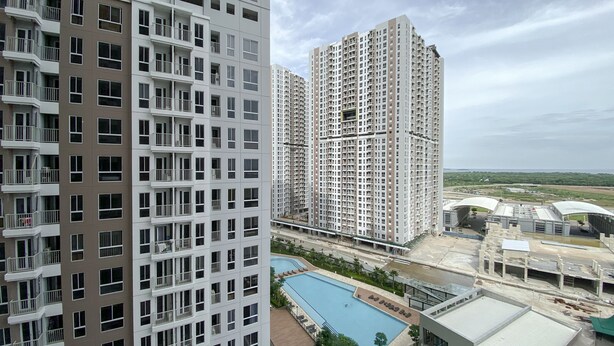A high-rise residential building with multiple balconies and a swimming pool area.