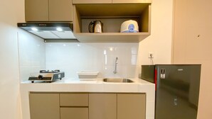 Eine kleine Küche mit Herd, Spüle und Kühlschrank.