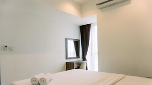 A hotel room with a neatly made bed, a desk with a chair, a mirror, and a window with curtains. - Nice And Fancy 1Br At Branz Bsd City Apartment (Pagedangan)