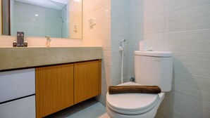 A modern bathroom with a toilet, shower, and vanity.