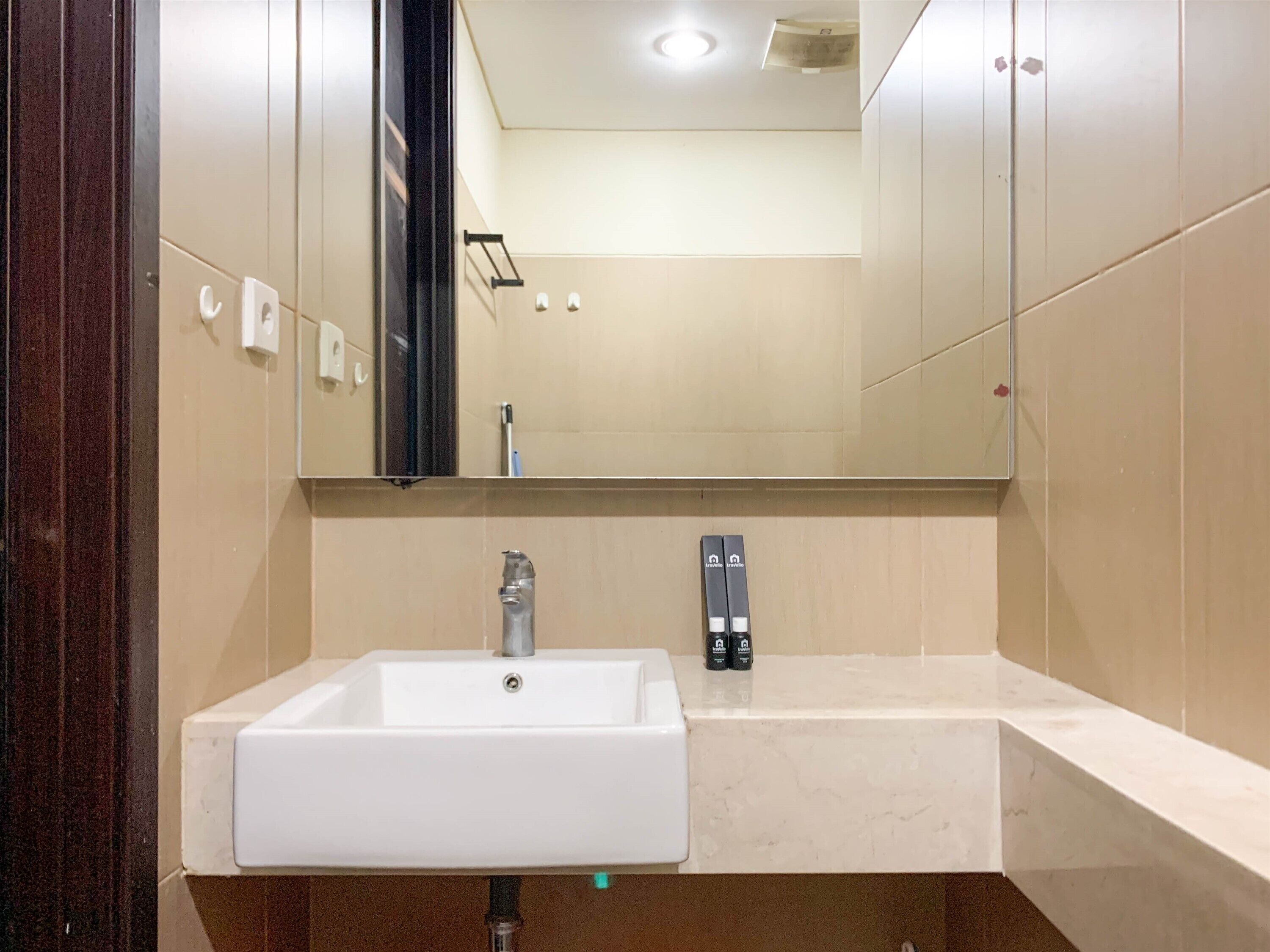 Une salle de bain moderne avec un lavabo blanc, un miroir et un porte-serviettes.