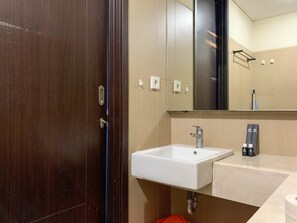A bathroom with a white sink, a mirror, and a towel rack.