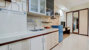 A modern kitchen with white cabinets, a stainless steel sink, and a blue countertop. - Nice Studio At 18Th Floor Atria Residences Gading Serpong Apartment (Gading Serpong)