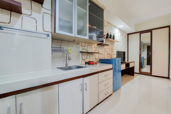Modern kitchen with an oven, microwave, and stainless steel sink.