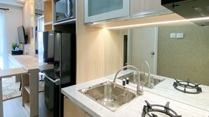 A modern kitchen with stainless steel appliances, a built-in microwave, and a gas stove. - Great Choice And Comfort Stay 2Br At Patraland Urbano Apartment (Bekasi)
