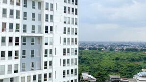 A high-rise building with multiple floors, each featuring a grid of windows and balconies. - Great Choice And Comfort Stay 2Br At Patraland Urbano Apartment (Bekasi)