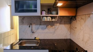 A kitchen with a marble backsplash, a stainless steel sink, and a range hood. - Good Choice 2Br At 12Th Floor Gateway Ahmad Yani Cicadas Apartment (Bandung)