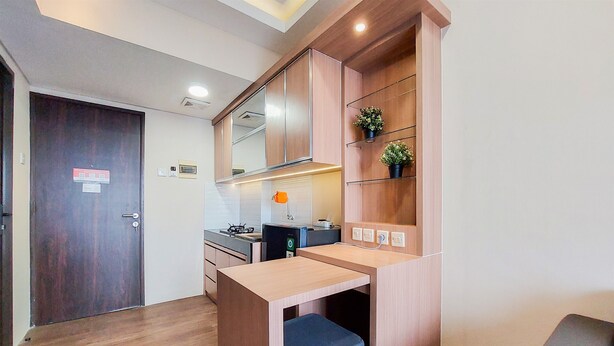 Una cocina compacta con armarios de madera, estufa integrada y una pequeña encimera.