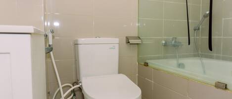 A bathroom with a toilet, a shower, and a bathtub.