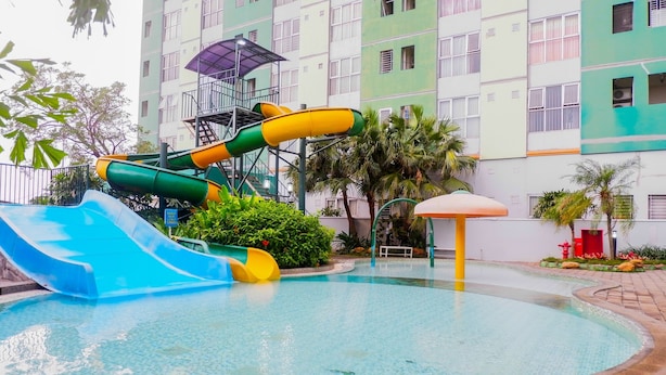 Une piscine avec un toboggan et un espace de jeux pour enfants.