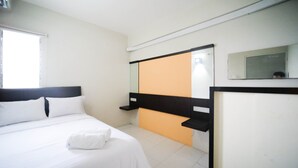Une chambre d’hôtel avec un lit, une fenêtre, un miroir et une porte dotée d’un cadre noir.
