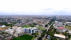 An aerial view of a cityscape with a mix of residential and commercial buildings, roads, and green spaces. - Cozy And Homey 2Br Tamansari Panoramic Apartment (Bandung)