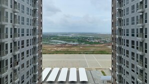 A high-rise building with a view of a flat landscape and distant buildings. - Restful And Cozy Studio Tokyo Riverside Pik 2 Apartment (Teluknaga)