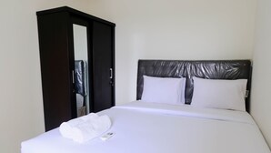 A neatly made bed with white linens and pillows, a black headboard, and a white towel on the side. - Good Deal 1Br Apartment At Parahyangan Residence (Bandung)