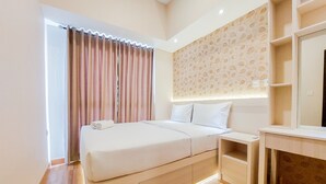 Una habitación de hotel moderna con una cama grande, mesitas de noche, un escritorio integrado y un espejo amplio.