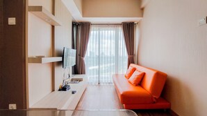Una sala de estar moderna con un televisor de pantalla plana, una mesa de centro de madera y un sofá naranja.