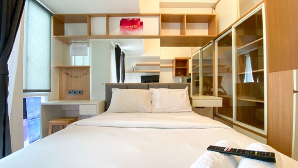 Une chambre d’hôtel avec un grand lit, une armoire, un bureau et une fenêtre.